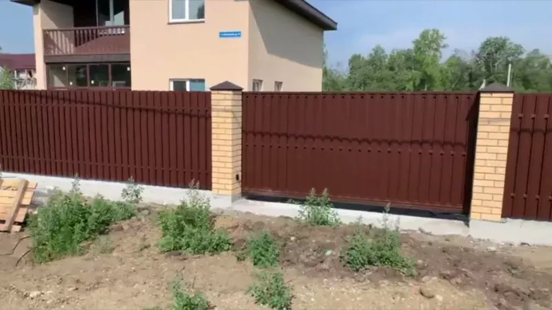 Забор из евроштакетника с кирпичными столбами и профнастилом